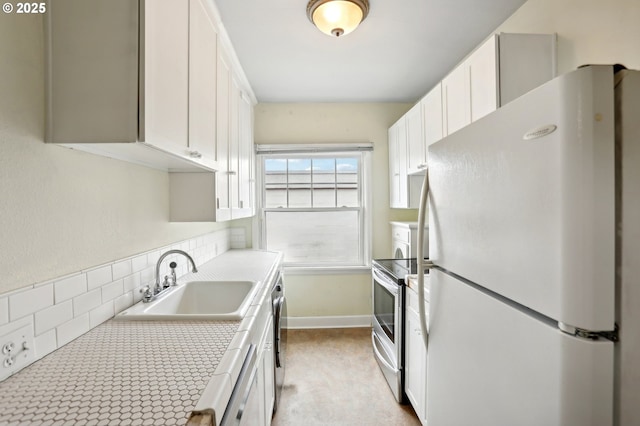 kitchen featuring appliances with stainless steel finishes, white cabinetry, tile counters, and sink