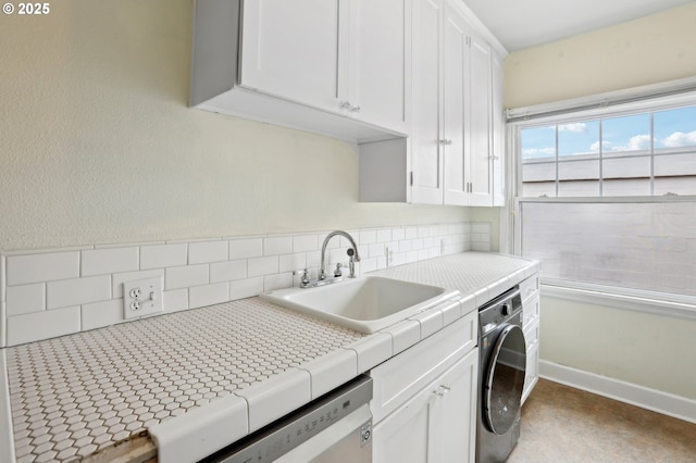 laundry area featuring washer / clothes dryer, sink, and cabinets