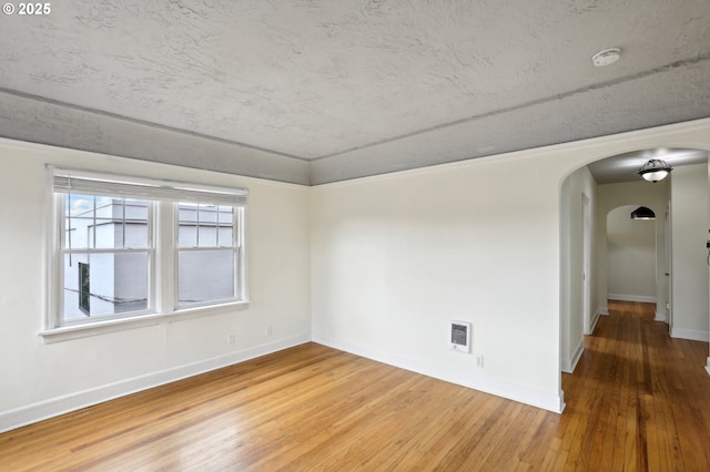 unfurnished room featuring wood-type flooring and heating unit