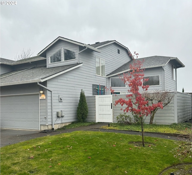 rear view of property with a garage and a yard