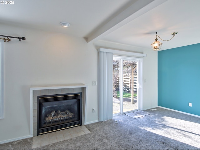 unfurnished living room featuring beamed ceiling, light colored carpet, and a tiled fireplace