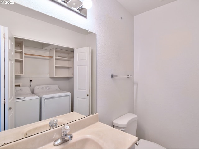 bathroom featuring vanity, washer and clothes dryer, and toilet