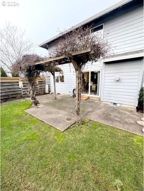 rear view of house featuring a yard and a patio area