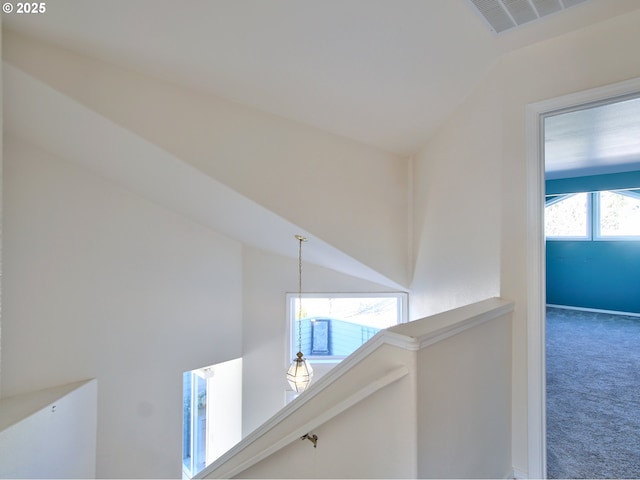 corridor featuring lofted ceiling and carpet