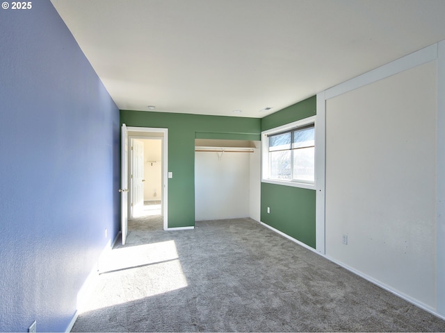 unfurnished bedroom featuring carpet flooring and a closet