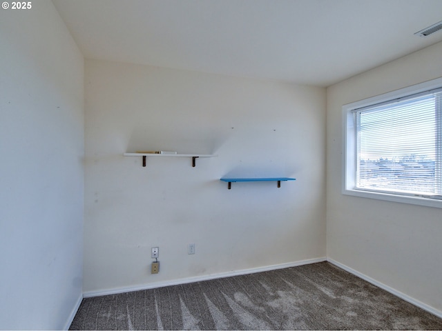 spare room with dark colored carpet