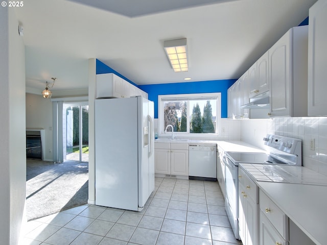 kitchen with white cabinetry, light tile patterned floors, white appliances, and tasteful backsplash