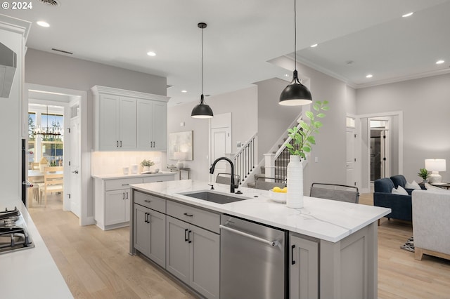 kitchen featuring sink, light stone counters, stainless steel dishwasher, an island with sink, and light wood-type flooring