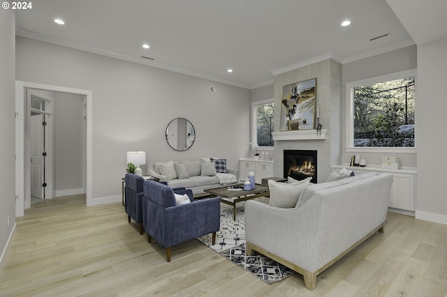 living room featuring a fireplace, crown molding, and light hardwood / wood-style flooring