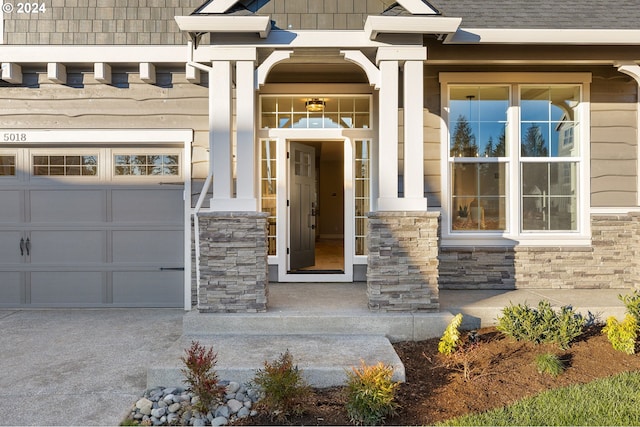 property entrance featuring covered porch and a garage