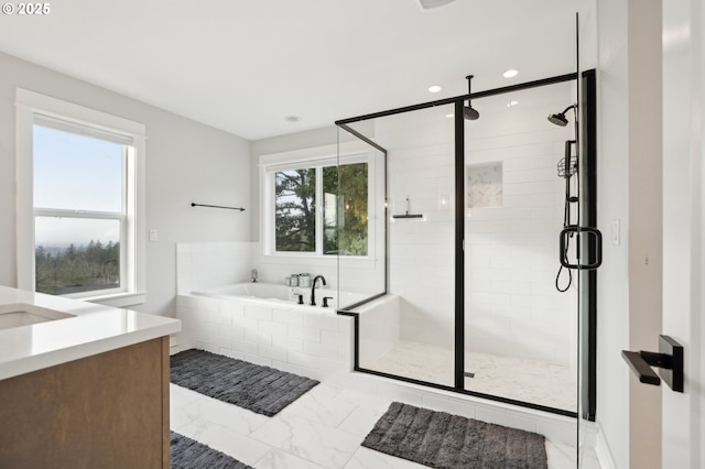 bathroom with vanity and shower with separate bathtub