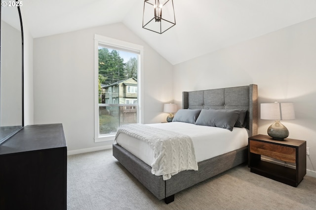 bedroom with light colored carpet and lofted ceiling