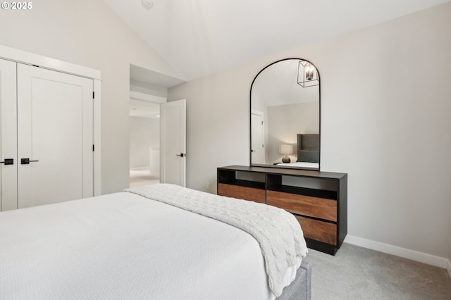 bedroom with light carpet, vaulted ceiling, and a closet