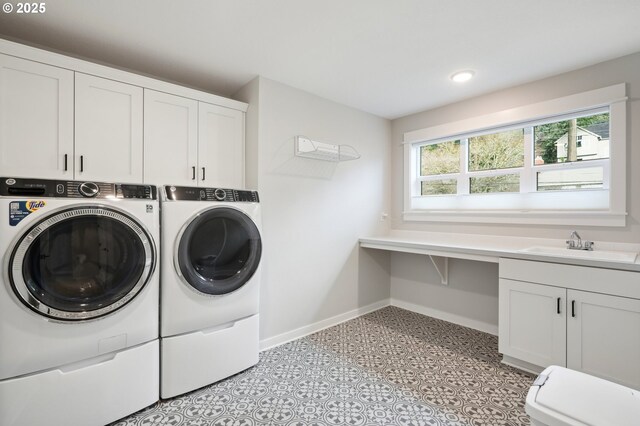 laundry area with washer and dryer, sink, and cabinets