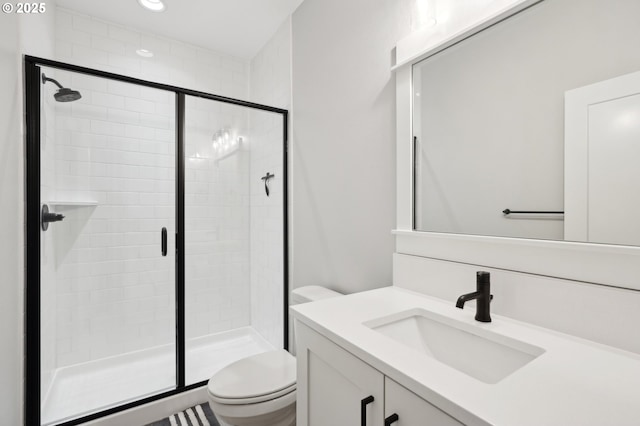 bathroom with vanity, toilet, and a shower with shower door