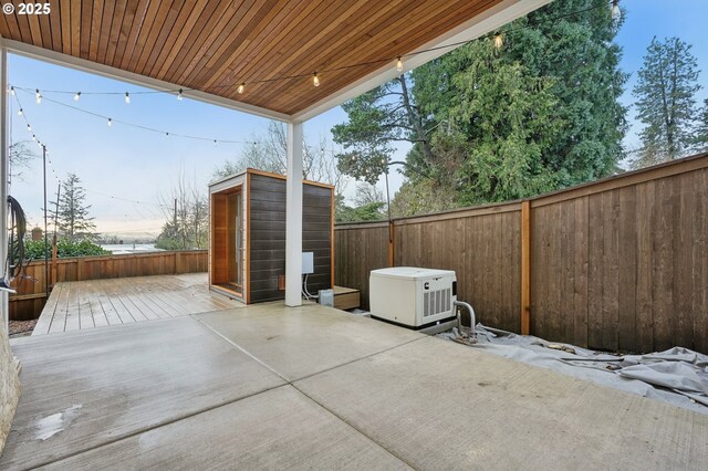 view of patio featuring a wooden deck and a storage shed