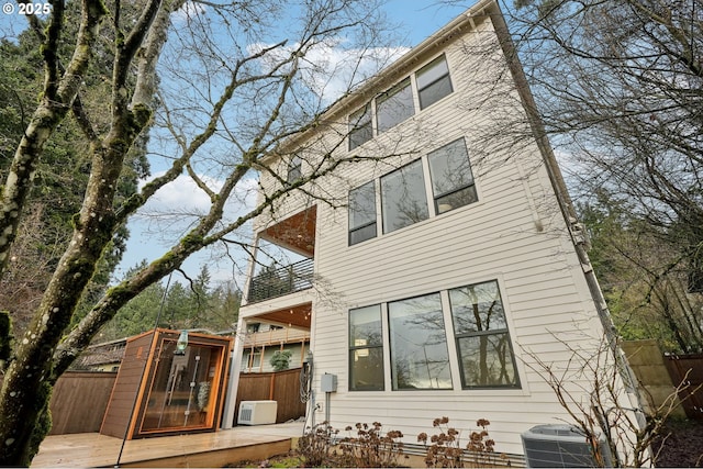 rear view of property with a balcony and cooling unit