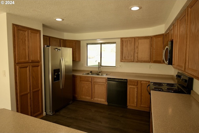 kitchen with sink, dark wood-type flooring, black appliances, and a textured ceiling