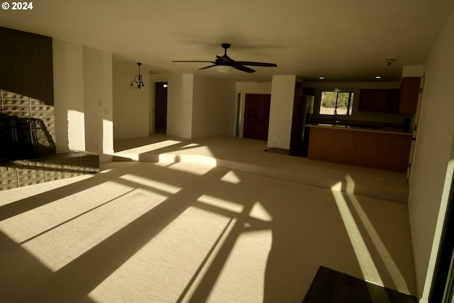 living room with ceiling fan, carpet floors, and a brick fireplace