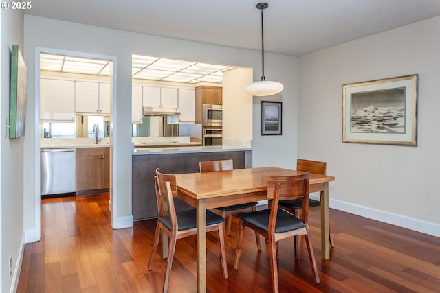 dining space with baseboards and dark wood-style flooring