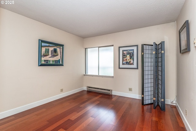 unfurnished room with a textured ceiling, baseboards, baseboard heating, and dark wood-type flooring