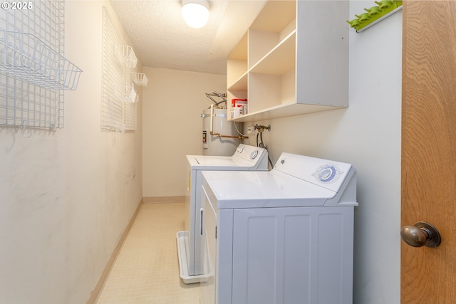 washroom featuring laundry area, baseboards, washer and clothes dryer, secured water heater, and a textured ceiling