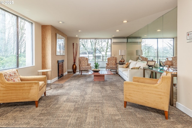 sitting room featuring a wall unit AC, a fireplace, baseboards, and recessed lighting