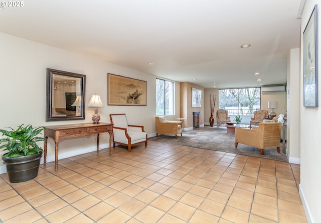 sitting room with recessed lighting, baseboards, an AC wall unit, and light tile patterned flooring