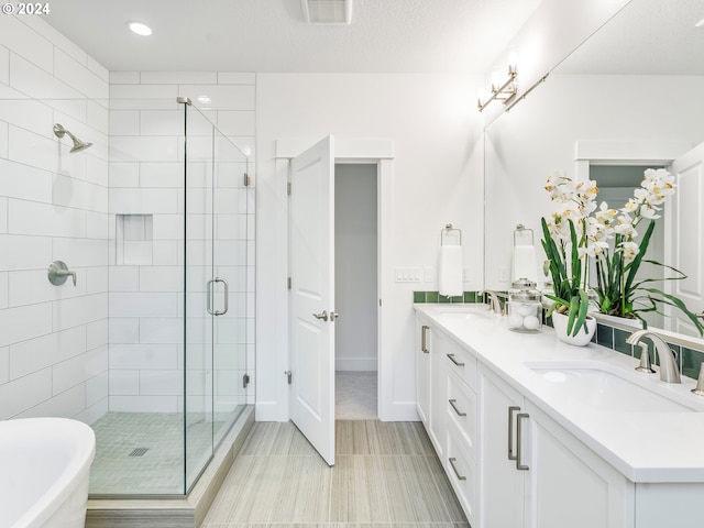 bathroom featuring vanity, shower with separate bathtub, and a textured ceiling