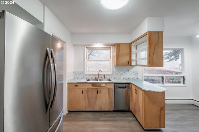 kitchen with stainless steel appliances, tasteful backsplash, light hardwood / wood-style floors, and sink