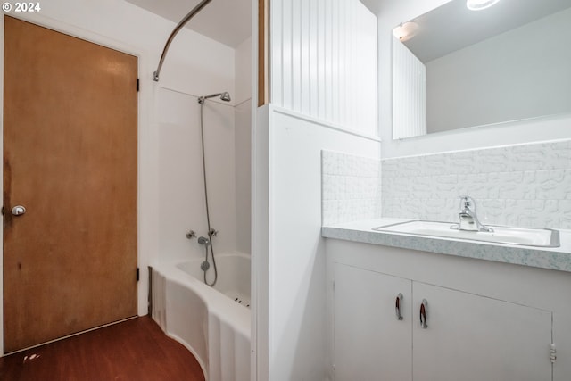 bathroom with vanity, hardwood / wood-style floors, backsplash, and shower / bath combination