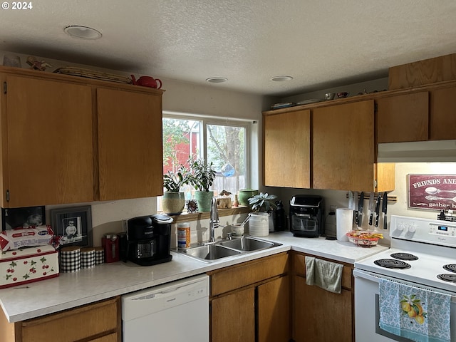 kitchen with white appliances, sink, and a textured ceiling