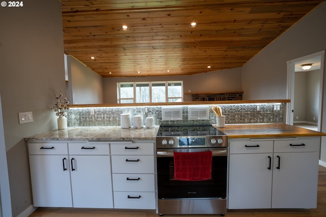 kitchen featuring backsplash, lofted ceiling, white cabinets, and stainless steel electric range oven