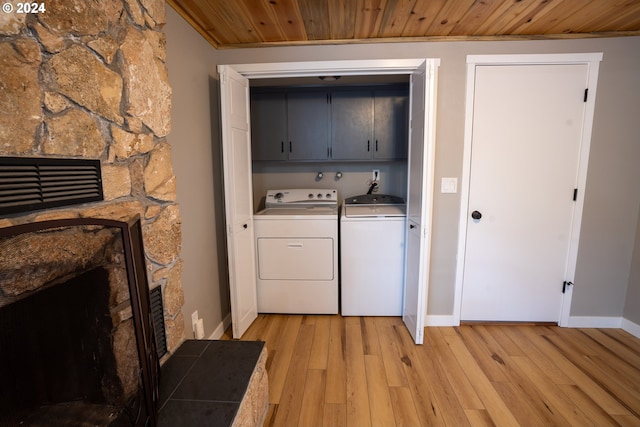 37075 Camp Creek Rd, Springfield, OR 97478 - laundry room with cabinet space, washing machine and clothes dryer, a fireplace, wooden ceiling, and light wood-style flooring