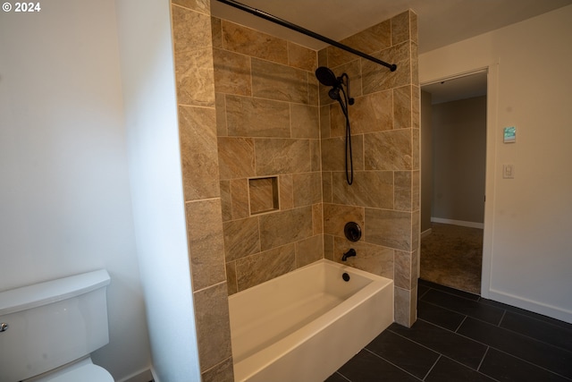 bathroom with toilet, tiled shower / bath combo, and tile patterned flooring