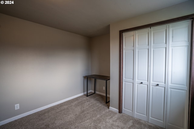 unfurnished bedroom featuring a closet and light carpet