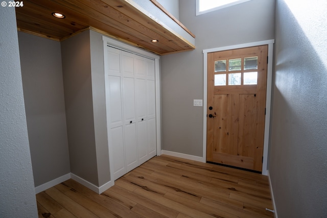 foyer with light hardwood / wood-style flooring, a healthy amount of sunlight, and wooden ceiling