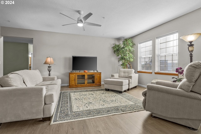 living room with ceiling fan, hardwood / wood-style flooring, and a textured ceiling