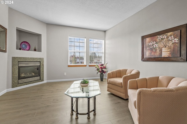 living room with wood-type flooring and a textured ceiling