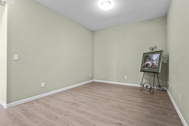 spare room with hardwood / wood-style floors and a textured ceiling