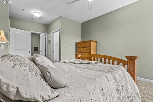 bedroom with ceiling fan, a textured ceiling, and carpet flooring