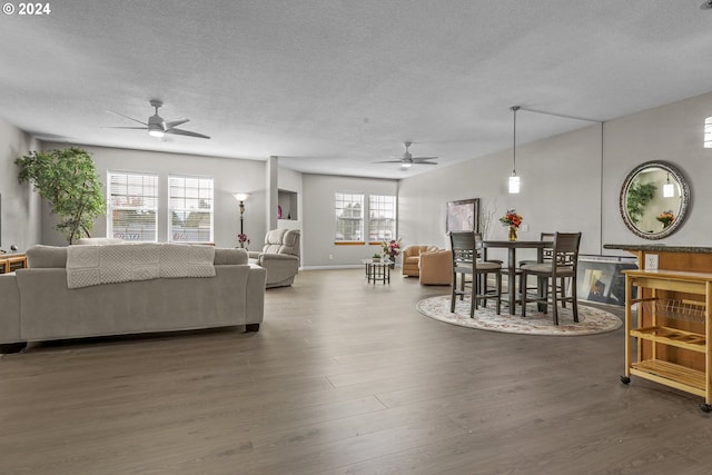 living room with ceiling fan, dark hardwood / wood-style floors, and a textured ceiling