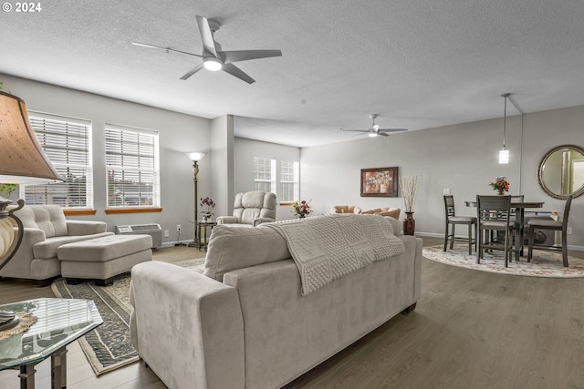 living room featuring ceiling fan, hardwood / wood-style floors, and a textured ceiling