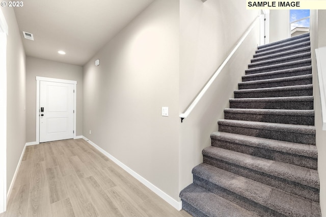 staircase with hardwood / wood-style floors