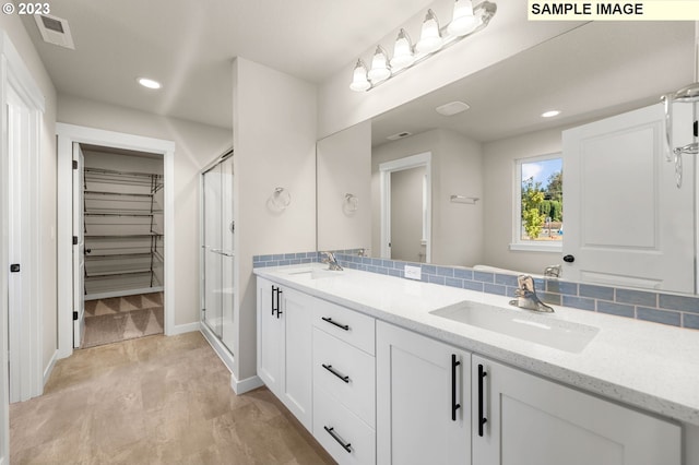 bathroom with vanity, tasteful backsplash, an enclosed shower, and hardwood / wood-style flooring