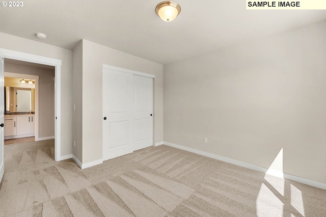 unfurnished bedroom with light colored carpet and a closet