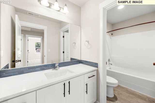 full bathroom with shower / tub combination, vanity, toilet, and hardwood / wood-style flooring