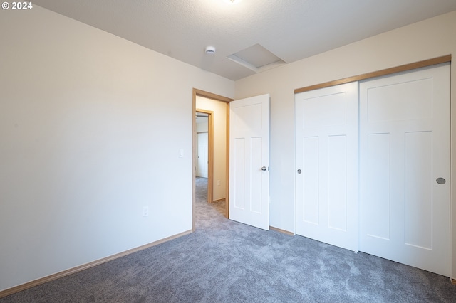 unfurnished bedroom with dark carpet and a closet