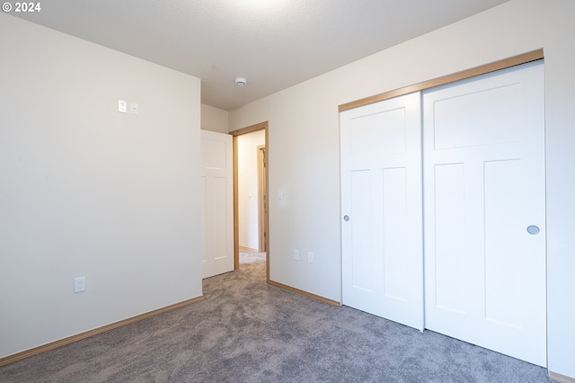 unfurnished bedroom with carpet flooring and a closet