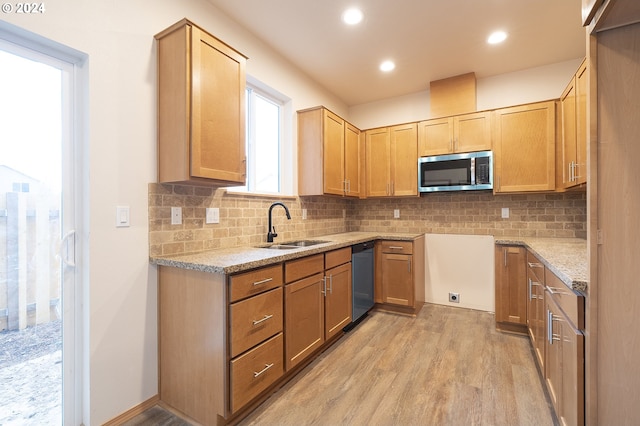 kitchen with decorative backsplash, sink, appliances with stainless steel finishes, and light hardwood / wood-style flooring